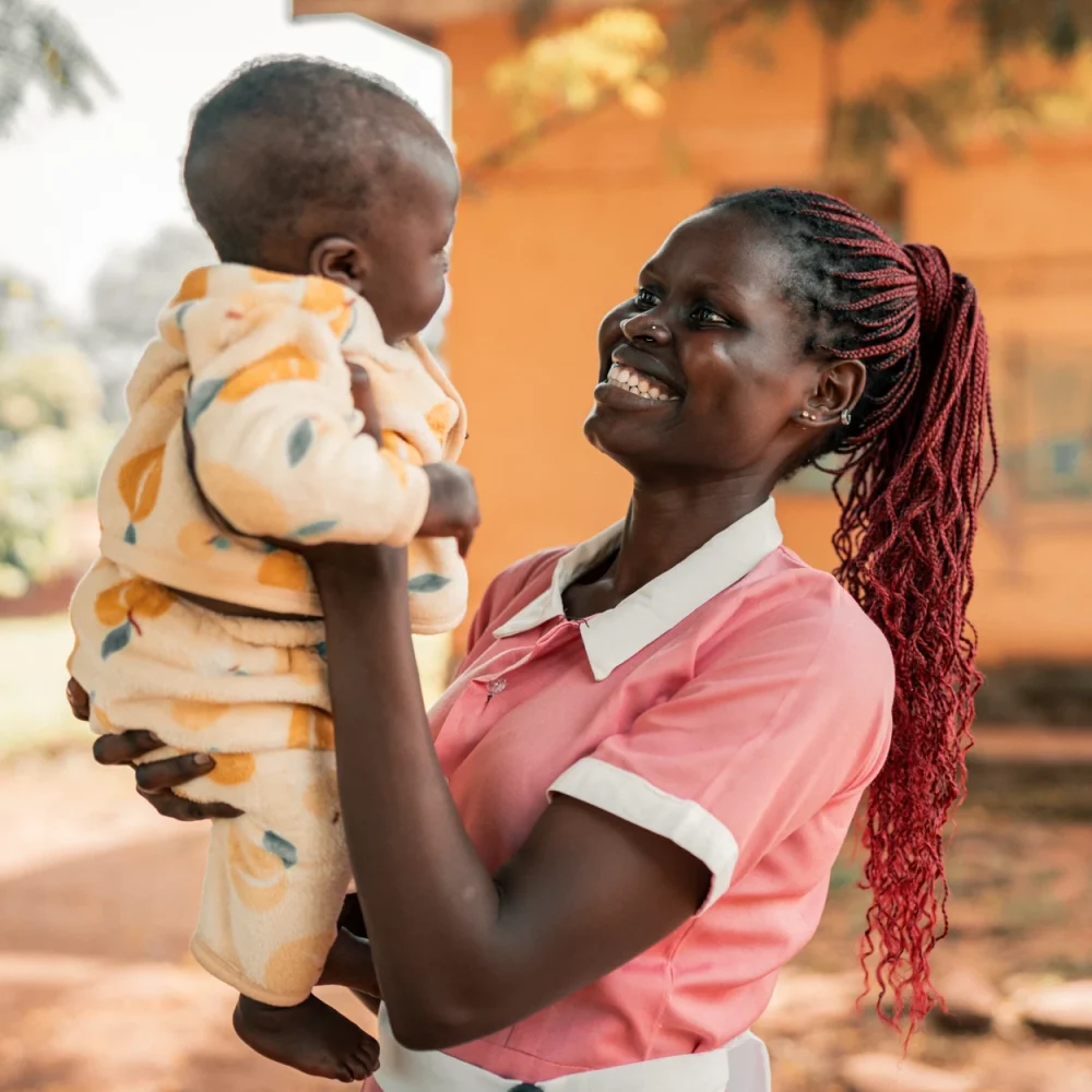 Barnmorskan Becky i Sudan håller en nyfödd bebis – Amref utbildar hälsoarbetare för trygg vård