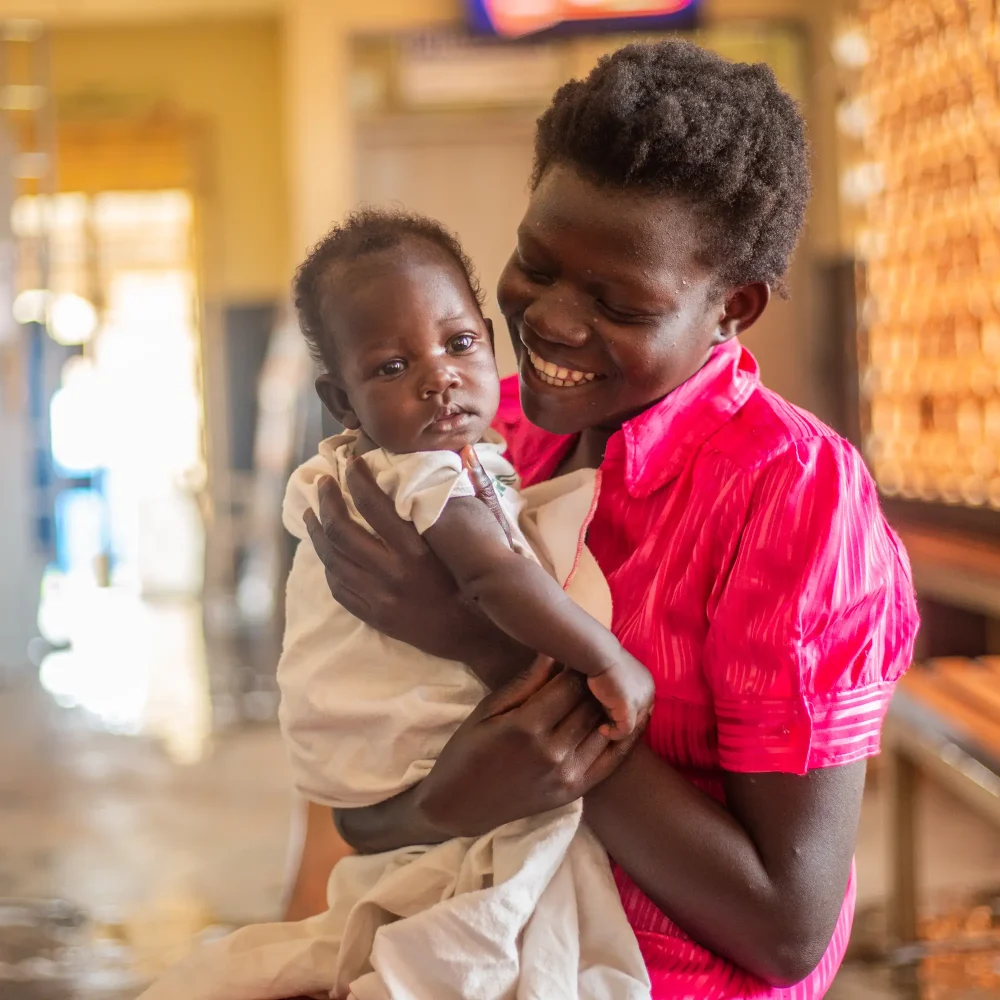 Kvinna med barn i Uganda – gåvobevis från Amref stödjer mödrahälsa.